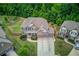 Expansive aerial view of a beautiful home with lush green lawn, mature trees, and a three car garage at 4240 Summer Breeze Way, Buford, GA 30518
