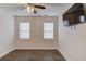Bright bedroom with ample natural light from two windows and featuring a ceiling fan and television at 4240 Summer Breeze Way, Buford, GA 30518