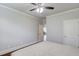 Bright bedroom with neutral walls, a fan, and a view into the hallway from the doorway at 4240 Summer Breeze Way, Buford, GA 30518
