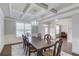 Elegant dining room showcasing coffered ceilings, hardwood floors, chandelier, and view to adjacent living space at 4240 Summer Breeze Way, Buford, GA 30518