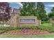 Welcoming 'Whispering Creeks' community sign surrounded by colorful flowers and landscaping at 4240 Summer Breeze Way, Buford, GA 30518
