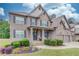Charming two-story home boasts a stone and brick facade, a well-manicured lawn, and a welcoming front porch at 4240 Summer Breeze Way, Buford, GA 30518