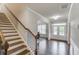 Spacious foyer featuring hardwood floors, staircase, wainscoting, and natural light from double doors at 4240 Summer Breeze Way, Buford, GA 30518