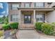 Inviting covered porch entrance features stone accents, double doors, and meticulously landscaped front yard at 4240 Summer Breeze Way, Buford, GA 30518