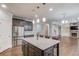 Kitchen island with stainless appliances and granite countertops with seating and view of living room and fireplace at 4240 Summer Breeze Way, Buford, GA 30518