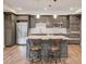 Modern kitchen with stainless steel appliances, kitchen island with chairs, and sleek wooden floors at 4240 Summer Breeze Way, Buford, GA 30518