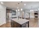 Well-equipped kitchen flowing into a living area, featuring stainless appliances and granite countertop island at 4240 Summer Breeze Way, Buford, GA 30518