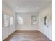 Bright living area featuring double doors and windows providing ample natural light, complemented by wood flooring at 4240 Summer Breeze Way, Buford, GA 30518
