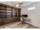 Home office with custom built-ins, a ceiling fan, and a modern adjustable desk at 4240 Summer Breeze Way, Buford, GA 30518