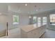 Modern kitchen with a large island, white cabinets, stainless appliances, and access to outdoor balcony at 533 Rubato Knl, Mcdonough, GA 30253
