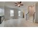 Bright living room featuring light wood floors, a ceiling fan, and staircase access at 533 Rubato Knl, Mcdonough, GA 30253