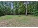 Backyard featuring a large grassy area surrounded by trees and a bench at 600 Luckett Ct, Smyrna, GA 30080