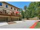 View of townhouse featuring a private deck with an orange umbrella, and a two-car garage at 600 Luckett Ct, Smyrna, GA 30080
