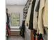 Organized walk-in closet with custom shelving, hanging rods, a storage bench, and a window for natural light at 600 Luckett Ct, Smyrna, GA 30080