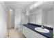 Well-lit bathroom featuring a double sink vanity, a large mirror, and wire shelving storage at 90 Cypress Dr, Covington, GA 30016