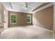 Spacious bedroom with a ceiling fan and tray ceiling detail, plus two windows offering natural light at 90 Cypress Dr, Covington, GA 30016