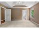 Neutral-toned bedroom featuring a view to a bathroom and a wide door, plus a fan and two windows at 90 Cypress Dr, Covington, GA 30016