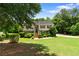 Charming home featuring a well-maintained lawn, mature trees, and beautiful landscaping at 90 Cypress Dr, Covington, GA 30016