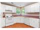 Practical kitchen with white cabinets, appliances and view of backyard at 90 Cypress Dr, Covington, GA 30016