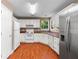 Functional kitchen featuring white appliances, cabinetry, and hardwood floors at 90 Cypress Dr, Covington, GA 30016