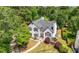 Aerial view of a traditional home with manicured lawn surrounded by mature trees at 9206 Denmeade Trce, Douglasville, GA 30135