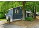 Two-story home features blue siding, a side garage, and a lush, tree-filled yard at 35 Pawn Dr, Carrollton, GA 30116