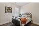 A simply decorated bedroom with a metal bed frame, plush carpet, and ample natural light from the window at 6977 Demeter Dr, Atlanta, GA 30349