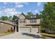 Charming two-story house with a stone and siding facade, a two-car garage, and a well-manicured front lawn at 6977 Demeter Dr, Atlanta, GA 30349