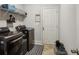 Modern laundry room with appliances, wire shelves, and tile flooring at 6977 Demeter Dr, Atlanta, GA 30349
