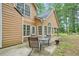 Home's rear exterior featuring a patio with seating, windows, and a fire pit in a lush, wooded backyard at 8035 Canter Ln, Alpharetta, GA 30009