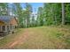 Expansive backyard featuring a fire pit and bordering dense trees, offering both entertainment and privacy at 8035 Canter Ln, Alpharetta, GA 30009