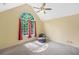 Bedroom with vaulted ceiling, large arched window, ceiling fan, chair, and neutral carpet at 8035 Canter Ln, Alpharetta, GA 30009