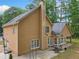 Tan two-story home featuring a backyard patio, basketball hoop, and lush green trees at 8035 Canter Ln, Alpharetta, GA 30009