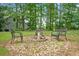 Backyard fire pit surrounded by chairs, creating a cozy outdoor gathering spot among the trees at 8035 Canter Ln, Alpharetta, GA 30009