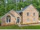 Traditional brick home with manicured lawn and beautiful architectural details in a wooded setting at 8035 Canter Ln, Alpharetta, GA 30009