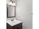 Cozy half bathroom with wood vanity and white countertop and a framed wood mirror at 8035 Canter Ln, Alpharetta, GA 30009