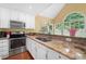 A spacious kitchen featuring stainless steel appliances, and a view of the lush greenery through a large window at 8035 Canter Ln, Alpharetta, GA 30009