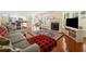 An open-concept living room showcasing an adjacent kitchen, fireplace, and comfortable sectional sofa at 8035 Canter Ln, Alpharetta, GA 30009