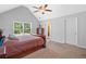 Bright main bedroom featuring a ceiling fan, vaulted ceiling, carpet, and a large window at 8035 Canter Ln, Alpharetta, GA 30009