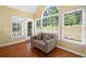 The sunroom features large windows, allowing an abundance of natural light and a cozy loveseat at 8035 Canter Ln, Alpharetta, GA 30009