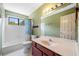 Bathroom with vanity sink, full bath, green textured walls, and large window at , Marietta, GA 30064