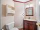 Powder room with wood vanity, patterned wallpaper, mirror, and a white woven shelf at , Marietta, GA 30064