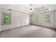 Spacious primary bedroom featuring three large windows, tray ceilings, and plush carpeting at , Marietta, GA 30064