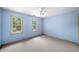 Bright bedroom painted light blue with two windows and neutral carpeting at , Marietta, GA 30064