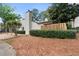 Cozy home featuring wood siding, a chimney, a neat hedge, and beautiful surrounding trees at 1104 Country Ct, Lawrenceville, GA 30044