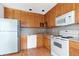 Efficient kitchen featuring white appliances and warm wood cabinets, providing ample storage at 1104 Country Ct, Lawrenceville, GA 30044