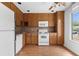 Functional kitchen with wood cabinetry, white appliances, and natural light from the window at 1104 Country Ct, Lawrenceville, GA 30044