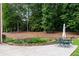 Backyard features a stone retaining wall with a garden, mature trees, and an outdoor seating area at 130 Robin Rd, Marietta, GA 30067