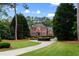 Stately brick home featuring a circular driveway, mature landscaping, and classic architectural details at 130 Robin Rd, Marietta, GA 30067