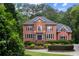 Charming two-story brick home with a manicured lawn, mature trees, and blue shutters at 130 Robin Rd, Marietta, GA 30067